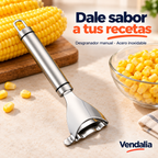 Portada Vendalia: desgranador de elote plateado con mango cilíndrico de acero cepillado, aros finos negros, aro metálico para colgar, cabeza ancha triangular curva y cuchilla dentada transversal. Alimentos y ambientación no incluidos.