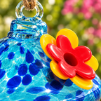 Alimentador de colibrí azul de vidrio con flor roja y amarilla — detalle