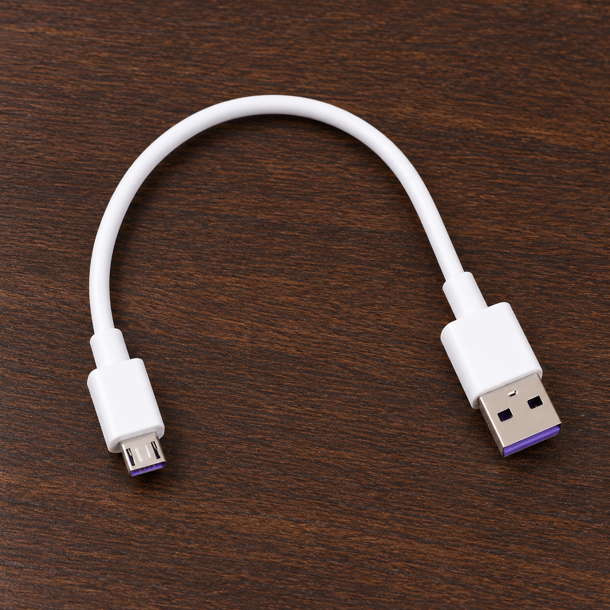 Cable blanco de 31 cm extendido sobre una mesa.