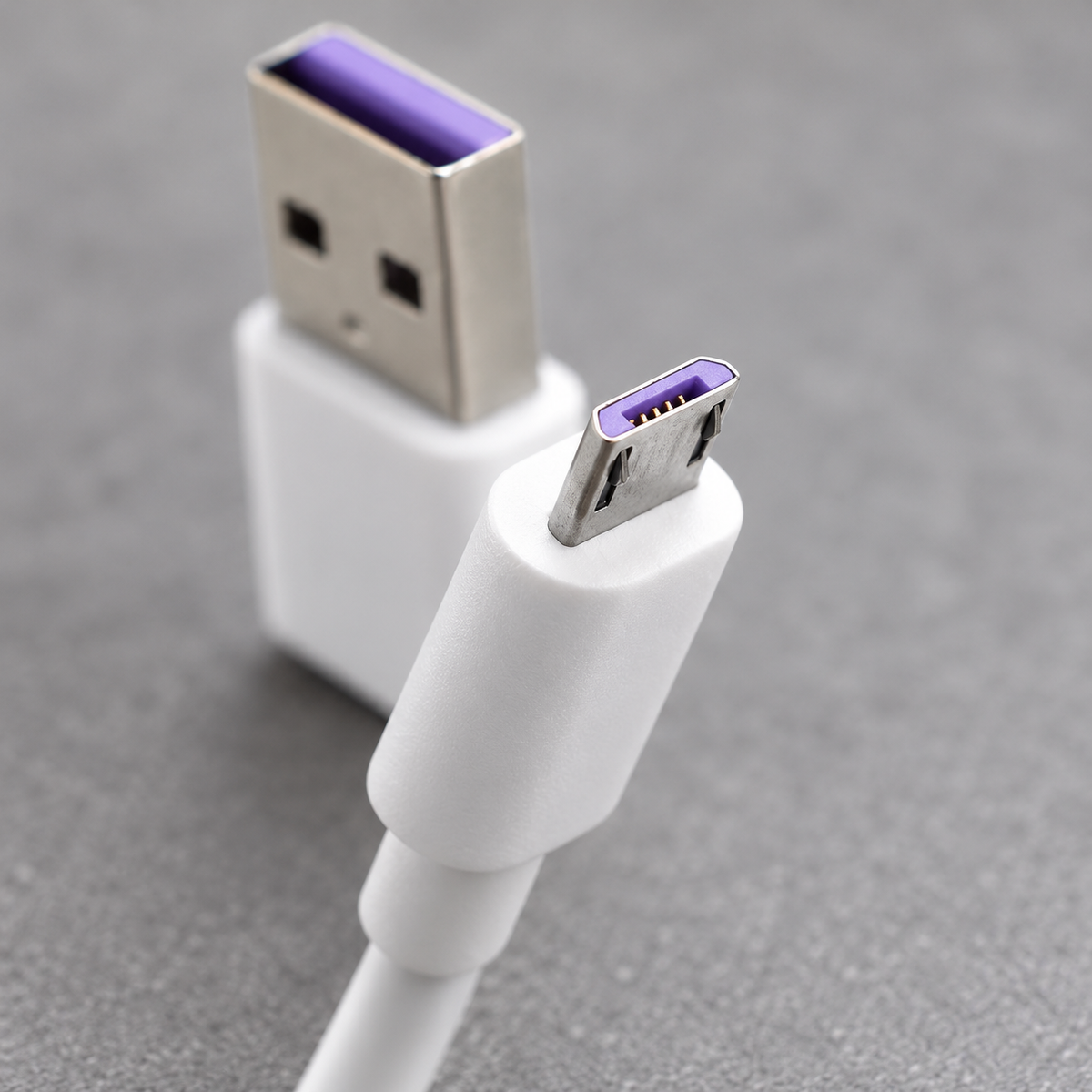 Detalle del conector Micro USB y del extremo USB-A del cable blanco.