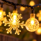 Tramo de luces solares cálidas con copos y esferas — detalle