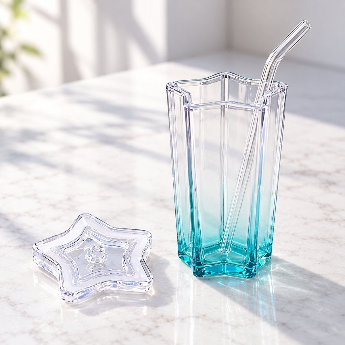 Vaso de estrella con tapa separada y popote de vidrio.
