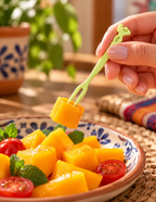Tenedor pequeño de dos puntas tomando fruta; alimentos y vajilla no incluidos