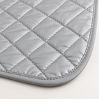 Tapete rectangular gris metálico para planchar de 48 x 84 cm, acolchado con costuras diagonales romboidales y ribete gris de esquinas redondeadas. — detalle del producto