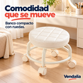 Banco bajo giratorio blanco con asiento redondo acolchado y costuras de cuadros, cuatro patas curvas unidas por aro circular y cuatro ruedas dobles crema — portada Vendalia