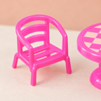 Detalle parcial de una silla y la mesa del set de cocina infantil, en rosa.