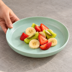 Plato verde menta de 20 cm mostrado desde un ángulo lateral con fruta; alimento no incluido.