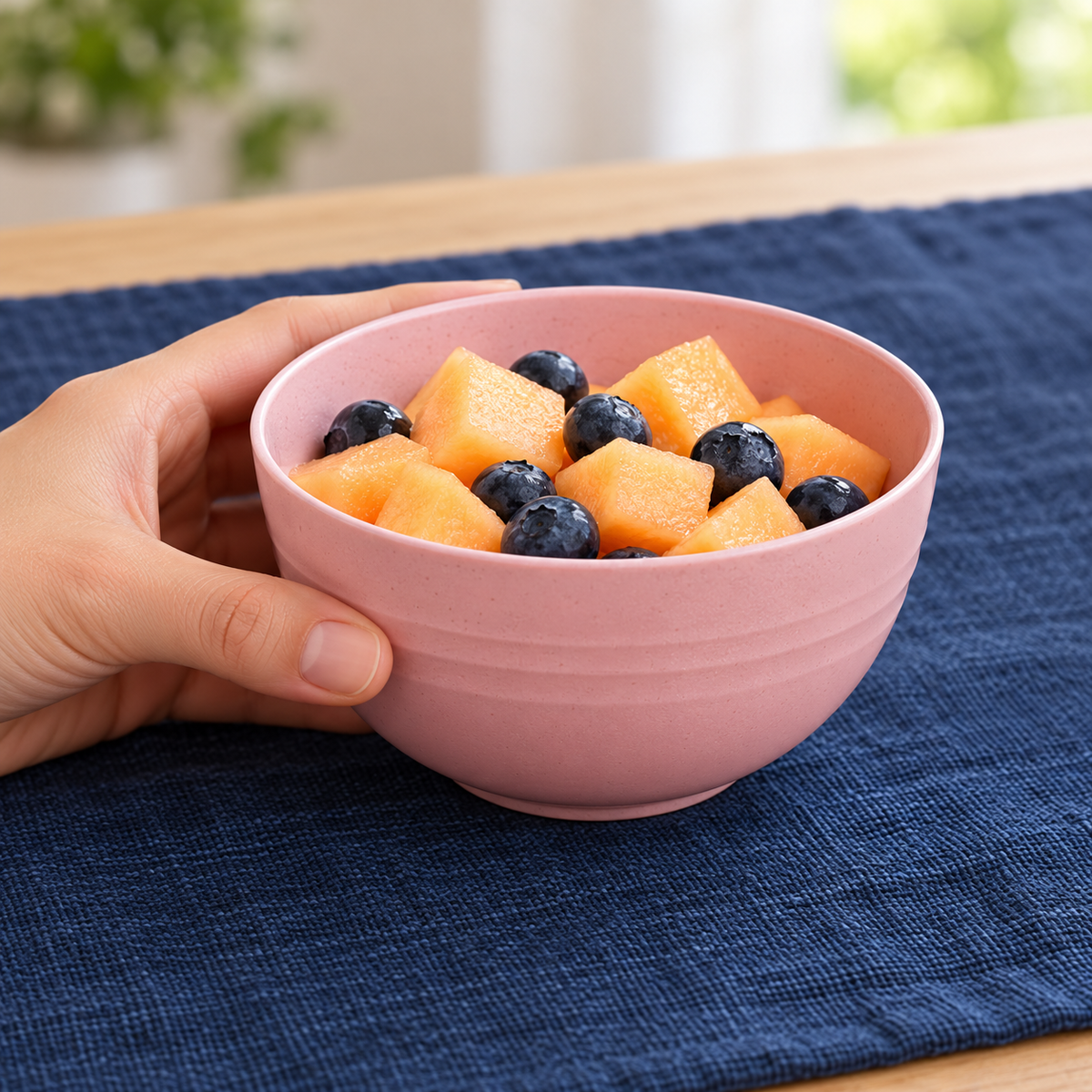 Bowl rosa de 350 ml en uso para servir una porción de fruta; alimentos no incluidos.