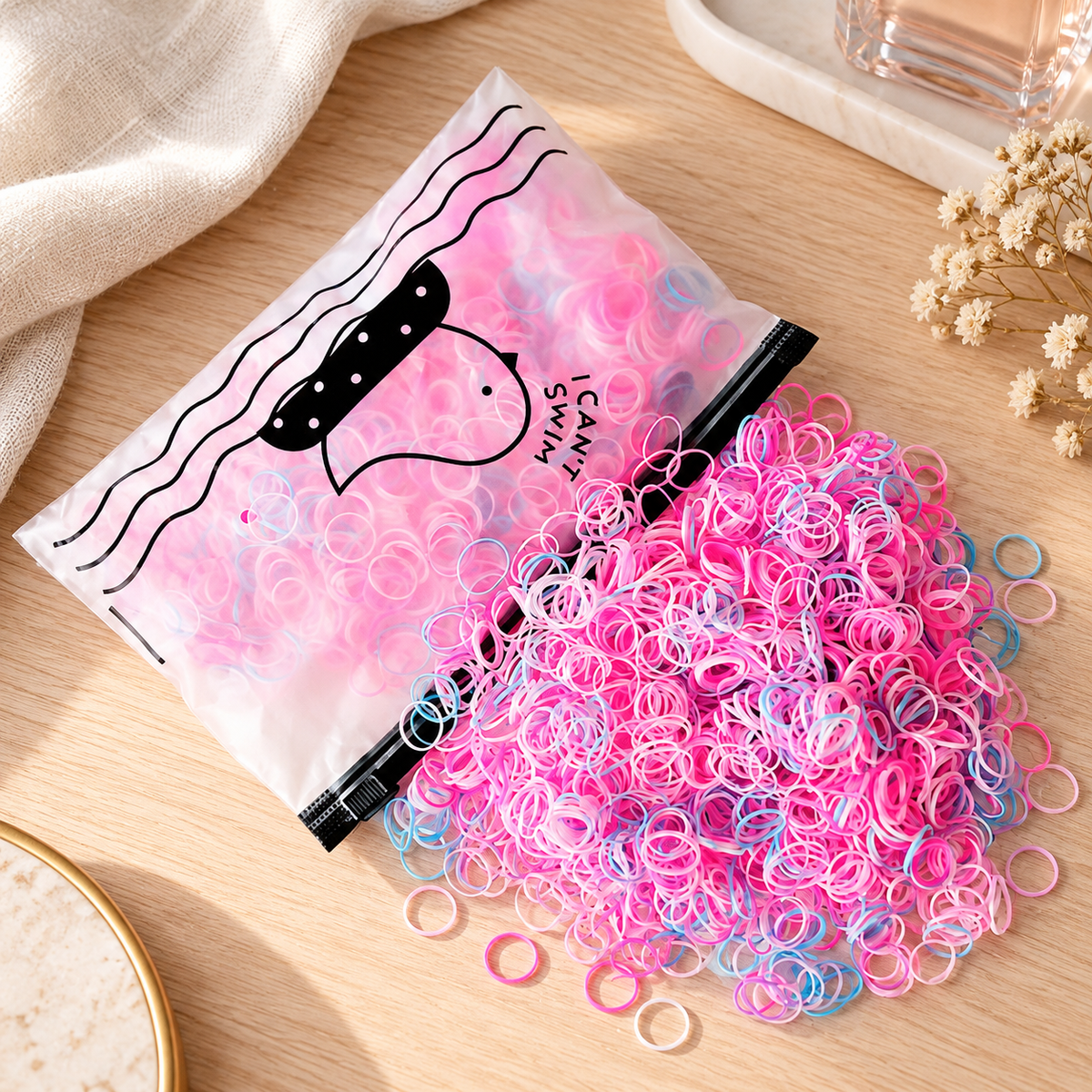 Ligas elásticas para cabello en ambiente de hogar — Vendalia. La unidad de venta corresponde a una bolsa de ligas. Los accesorios del ambiente no están incluidos.