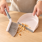 Escoba y recogedor en uso para migajas sobre una mesa