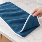 Toalla de microfibra azul con orilla blanca — Vista de detalle.