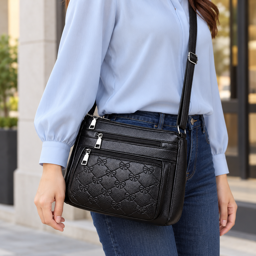 Bolsa negra con bordado y cierres — vista de uso y detalle