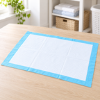 Protector Absorbente Desechable Multiusos 45x60cm/50 pcs en ambiente de hogar — Vendalia. La fotografía muestra el detalle de un protector; la presentación de venta es el paquete de 50 piezas de 45 × 60 cm.