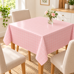 Mantel de plástico 137*137cm rosa en ambiente de hogar — Vendalia. La fotografía muestra una sugerencia de uso del mantel. Muebles y objetos decorativos no incluidos.